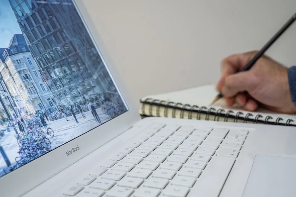 Deux hommes d’affaires examinent des données boursières à l’aide d’un smartphone et d’un ordinateur portable dans un bureau moderne.